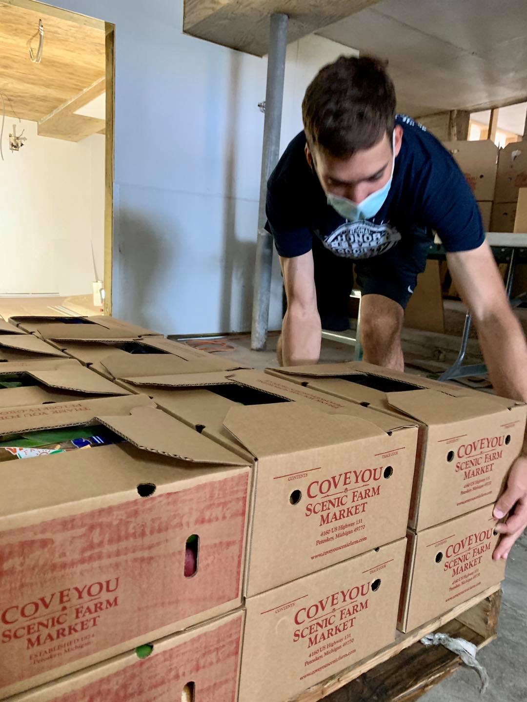 Will Coveyou lifting and stacking boxes of produce.